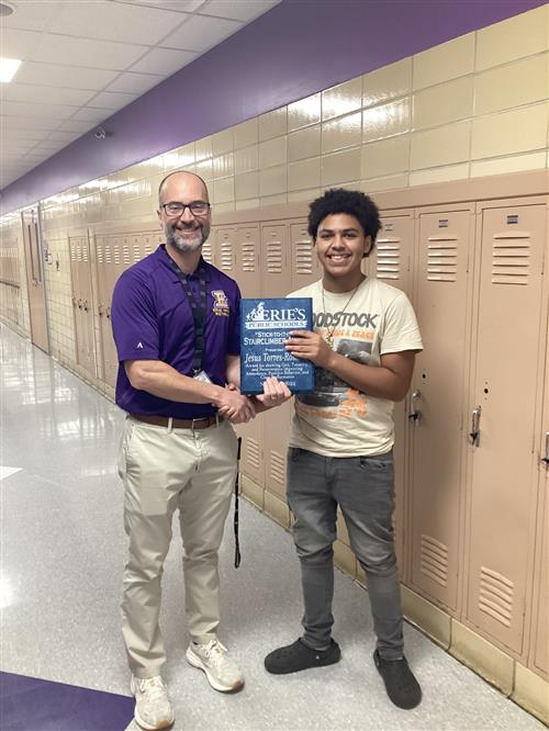 Jose Torres-Rosado, Erie High's November Stairclimber, poses with his plaque and Principal Don Orlando.